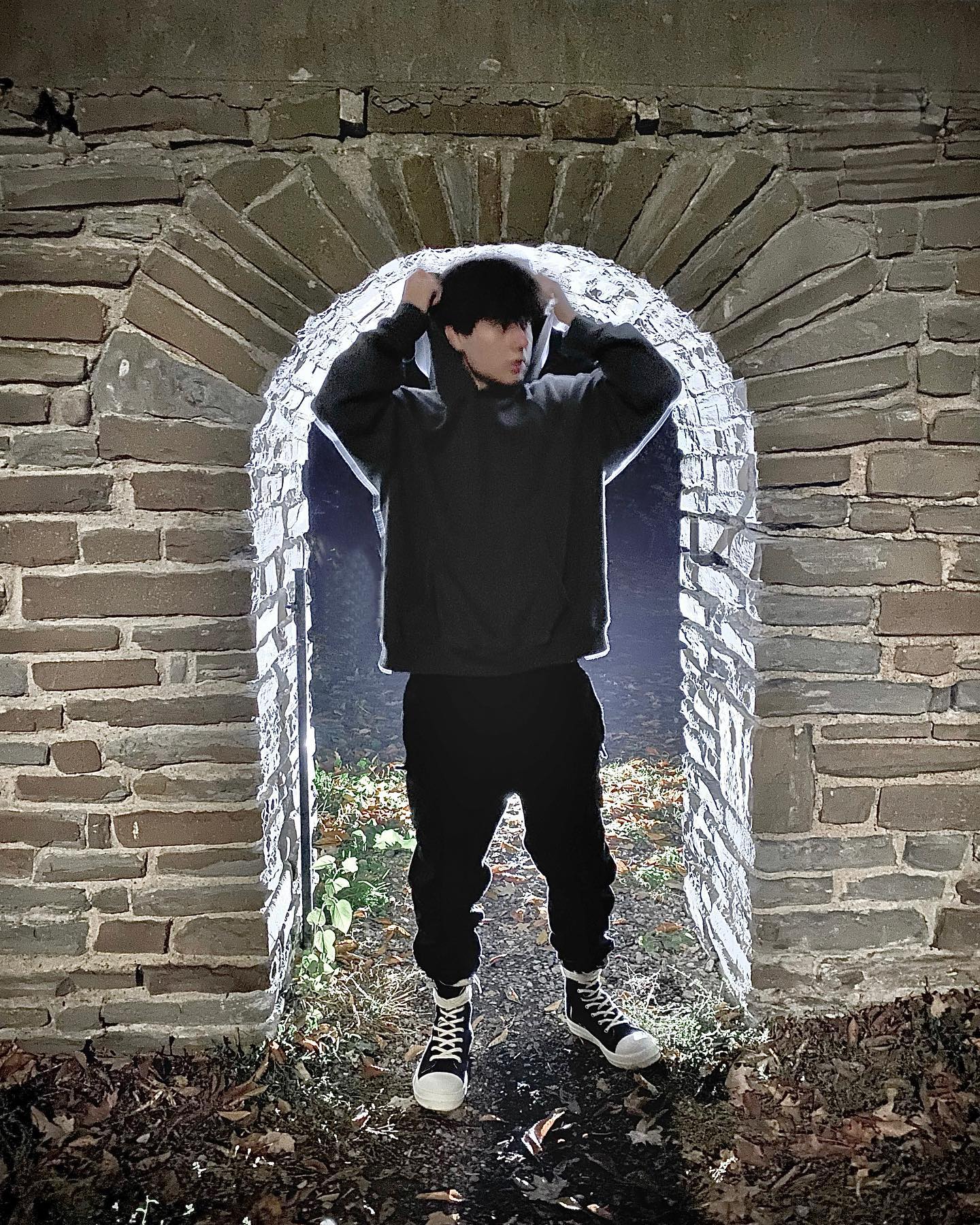 towa crouched in a brick tunnel, low angle